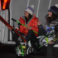 <p>Two women, carrying winter sports gear, ride in the back of Hickory &amp; Tweed&#x27;s van as part of the &quot;Frosty Day&quot; parade in downtown Armonk.</p>