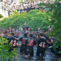 <p>Rye players celebrate their win by jumping in the creek, after beating Harrison.</p>
