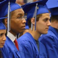 <p>A group of graduates pay close attention to the speakers at the Abbott Tech High School graduation.</p>