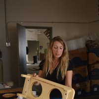 <p>Marci Klein, founder of Modify Furniture, inspects a stand for dog bowls at her Bridgeport factory space.</p>