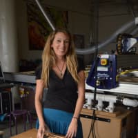<p>Marci Klein, founder of Modify Furniture of Bridgeport, works on a desk with custom insets, including her milk-and-cookies tray.</p>