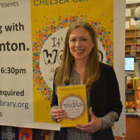 <p>Chelsea Clinton poses with a copy of her new book, &quot;It&#x27;s Your World&quot; during a visit at the Chappaqua Library.</p>
