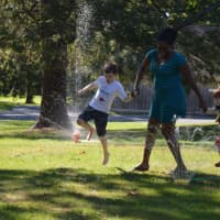<p>Maddox Bragg, his babysitter Stacy-Ann Hercules and his little brother, Lincoln, frolic in the sprinklers at the Pequot Water Games in Fairfield.</p>