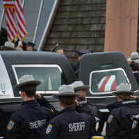 <p>The casket of Putnam County Undersheriff Peter Convery is placed into a hearse following indoor funeral services at a Mahopac church.</p>