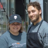 <p>Maycie Maringer and Sam Ralbovsky pose in front of the Nosh Hound food truck in Stamford Tuesday. Ralbovsky is a Stamford native.</p>