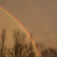 <p>Sections of two large rainbows are visible in the sky over Carmel following a Sunday afternoon downpour. The upper rainbow is faded while the lower rainbow offers a brighter contrast to the background.</p>