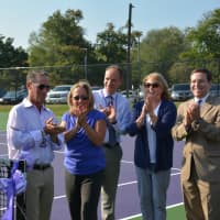 <p>Community members give their applause just after a ribbon cutting to mark the dedication of the John Jay tennis courts.</p>