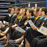 <p>Following along in the program at the Ridgefield High graduation Friday.</p>
