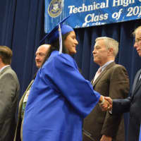 <p>A happy graduate shakes hands with Mayor Mark Boughton at the Abbott Tech High School graduation.</p>