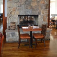 <p>The main dining room at Hub and Spoke features a stone fireplace.</p>