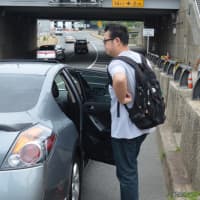 <p>Nick Bai gets into a car for a ride across the bridge.</p>