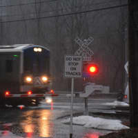 <p>A Metro-North train passes through the Commerce Street crossing in Valhalla during heavy rain on Wednesday.</p>