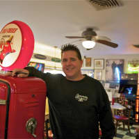 <p>Sycamore owner Patrick Austin poses next to a gas pump.</p>