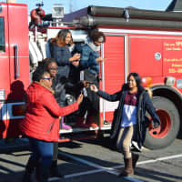 <p>Volunteers relax and take photos in front of the fire truck before getting on buses to their volunteer sites.</p>