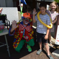<p>Casey the clown poses with children as they do balloon demonstrations.</p>