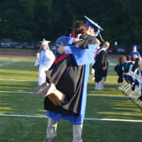 <p>A new Fairfield Ludlowe High School student hugs one of his teachers at commencement Thursday.</p>