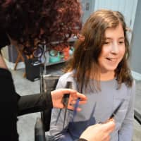<p>Industrie Stylist Denise Santero of Hawthorne cuts a long blue hair extension to match the length of 10-year-old Olivia Vigliotti&#x27;s hair.</p>