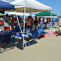 <p>Friends and families gather underneath tents to keep cool at Short Beach.</p>