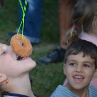 <p>Mount Pleasant&#x27;s Samantha Keltz, 7, participates in the doughnut fishing segment at the Armonk Fall Festival. Her father, Gary Keltz, held the pole.</p>