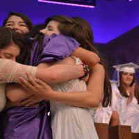 <p>A new John Jay High School graduate receives a group hug following a performance by The Treblemakers, which is a co-ed student a cappella group. The performance was held as part of the 2016 commencement.</p>