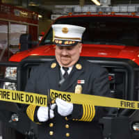 <p>Croton Falls Fire Chief Jason Blauvelt cuts fire line tape (used as a ribbon) for the grand opening of the new firehouse.</p>
