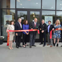 <p>Sol Glastein, co-owner of Massage Envy, cuts the ribbon in front of his new Closter Plaza location with his partner and daughter Marla Robinson (in purple).</p>
