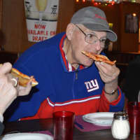 <p>A member of The Spartans bites into a slice of cheese pizza at Patsy&#x27;s Tavern and Restaurant in Paterson.</p>