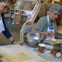 <p>Making baklava, step two: Betty Gakos of North Caldwell, left, and Ellen Dahlan of Bergenfield brush on liquid butter.</p>