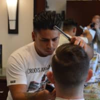 <p>Paolo Serpa of Royal Cuts Studio styles hair in My Salon Suite in Stamford on Monday morning. </p>
