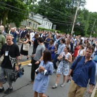 <p>A large press scrum, along with Hillary Clinton&#x27;s entourage, head down the King Street hill in downtown Chappaqua as part of the Memorial Day parade route.</p>