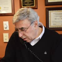 <p>Daily Treat Owner John Skoutakis answers the ever-ringing phone at the counter.</p>