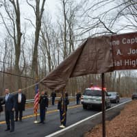 <p>Eric Jones&#x27; parents, Cindy and Ken, unveil a sign along Route 137 that is placed in honor of their son, a United States Marine who was killed in Afghanistan in 2009.</p>
