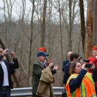 <p>Onlookers hold phone cameras out during the unveiling of signage along Route 137 in Pound Ridge that is in honor of Eric Jones.</p>