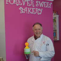<p>Sky Mercede of Forever Sweet Bakery in Norwalk poses in his store Monday.</p>
