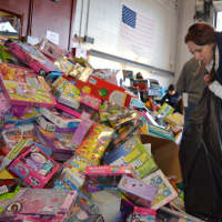 <p>A volunteer prepares gifts for loading during the 2015 Bergen PBA Toy Drive.</p>