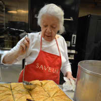 <p>Making baklava, step five: Maria Filler of Tenafly pours cold syrup over hot baklava for a nice glaze.</p>