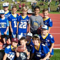 <p>Some future varsity players watch the game from the sidelines.</p>