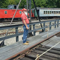 <p>Danbury Railroad Museum Volunteer Don Konen explains the function of the turntable in the railroad yard.</p>