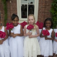 <p>Second-graders hand the graduates roses as they make their final walk to graduation.</p>