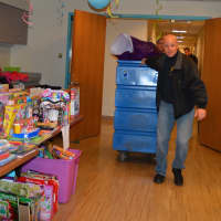 <p>Bergen County Police Officers bring gifts into an already-packed room.</p>