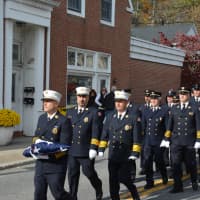 <p>Firefighters march in a procession through downtown Millwood from their old firehouse to their new one.</p>