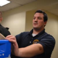 <p>Englewood Cliffs Police Officer Marc Krapels pushes a bin full of toys through the HUMC halls.</p>