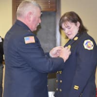 <p>River Vale Deputy Fire Chief Gregory Goodell Sr. gives his daughter, new Chief Kellie Goodell, her pin upon being sworn in on Friday afternoon.</p>
