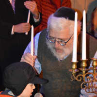 <p>Rabbi Yehoshua Hecht encourages a young participant to sing during a menorah lighting ceremony Stew Leonard&#x27;s in Norwalk Monday.</p>