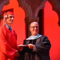 <p>A newly minted Fox Lane High School graduate receives his diploma at the 2016 commencement.</p>