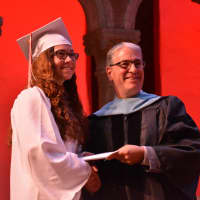 <p>A newly minted Fox Lane High School graduate receives her diploma at the 2016 commencement.</p>