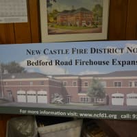 <p>A photo of a rendering that shows the proposed Bedford Road firehouse expansion in Chappaqua. The rendering is included with a voting information sign.</p>