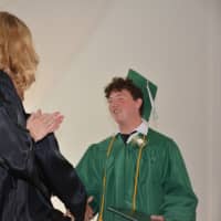 <p>A newly minted Webutuck High School graduate receives his diploma.</p>