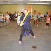 <p>Sensei Morgan Ewing helps little stormtroopers perfect their light saber skills at Jedi Academy in Fairfield.</p>