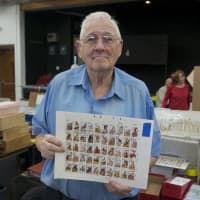 <p>A collector shows off some of his prized stamps at Saturday&#x27;s show.</p>